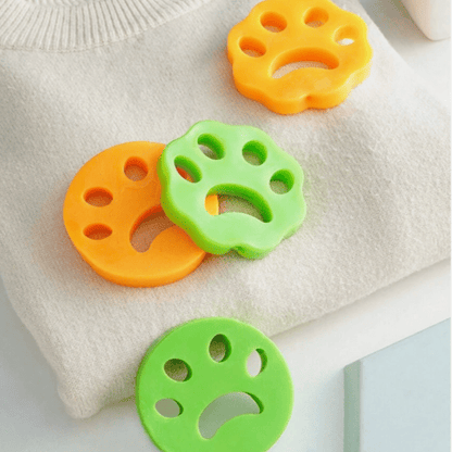 Colorful lint remover bars in green and orange placed on a white surface, designed to remove pet fur and lint from clothing.