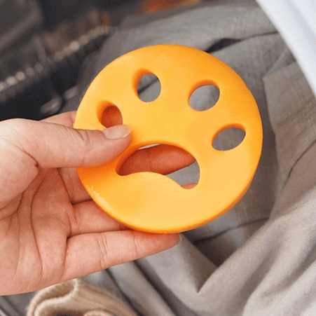 Washing machine lint catcher with floating disc and mesh filter bag, used to collect lint and debris during wash cycle.