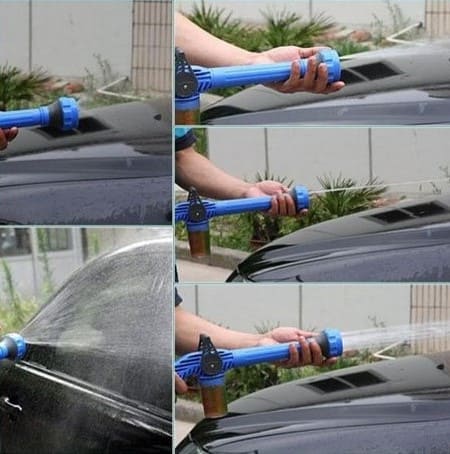 Water spraying from high-pressure spray gun for powerful cleaning of driveway or patio.
