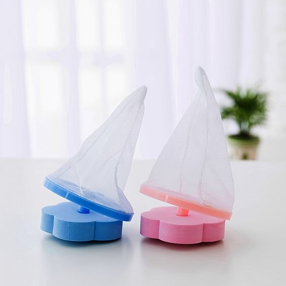 Two plastic washing machine lint mesh bags, one in blue and one in pink, designed to float on the water surface to catch lint and debris.